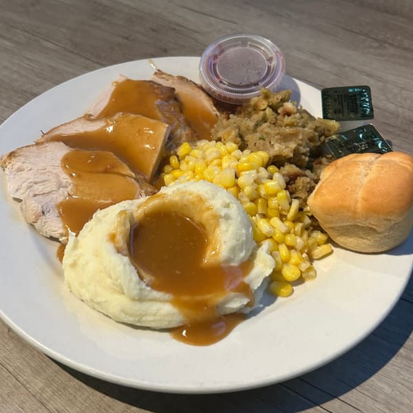 A plate of turkey, mashed potatoes, gravy, corn, stuffing, and a dinner roll from Sammy's Pub and Grill.